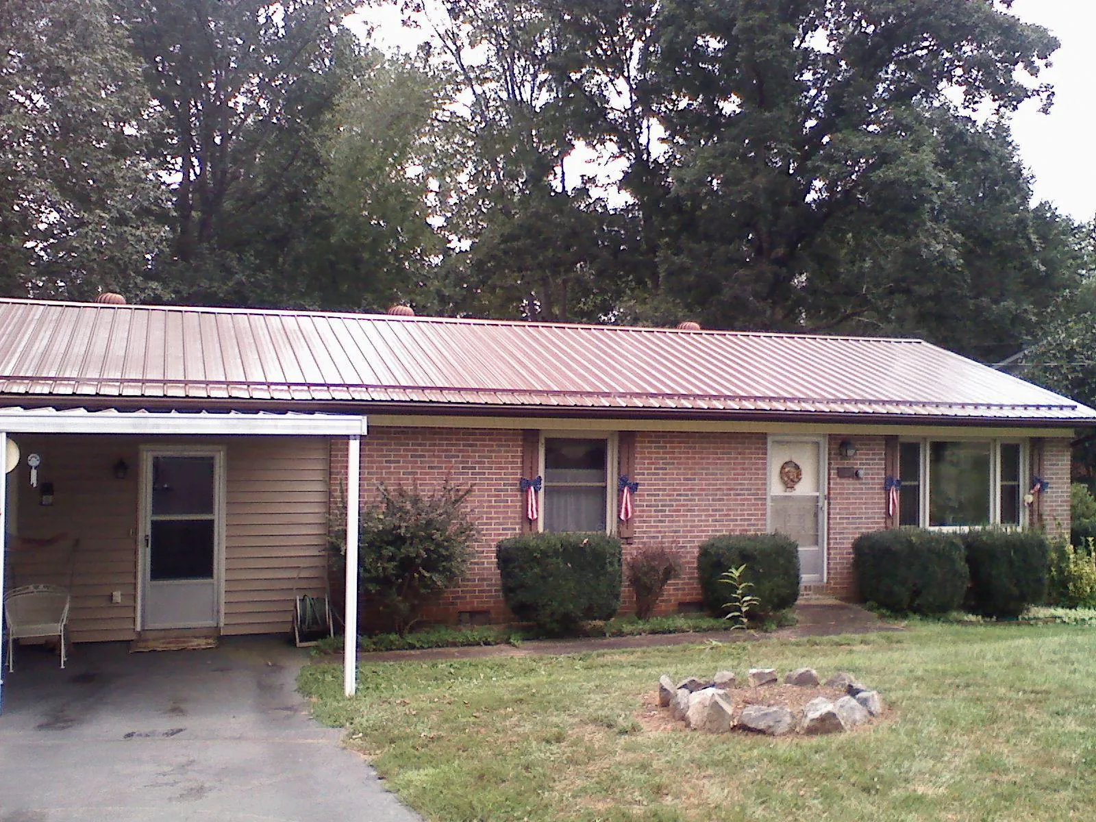 Bronze metal roof and carport on a brick ranch home — Roof Repair work by our crew in Leighton